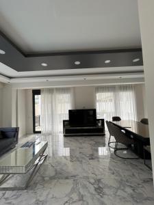 uma grande sala de estar com um sofá e uma televisão em Villa Zengin em Kemer