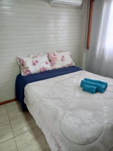 ein Schlafzimmer mit einem großen Bett mit rosa und weißen Kissen in der Unterkunft Pousada Encantos Da Montanha in Lauro Müller