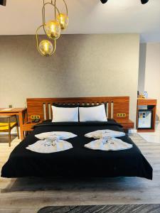 een slaapkamer met een zwart bed met 2 kussens erop bij İstanbul Airport Treekos Suite Hotel in Karaburun