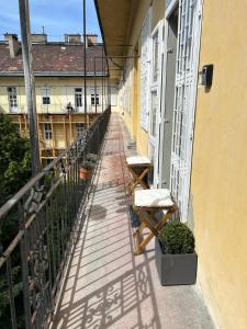 een balkon met 2 stoelen in een gebouw bij King 28 in the city center in Boedapest