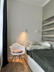een slaapkamer met een bed en een stoel naast een bed bij King 28 in the city center in Boedapest