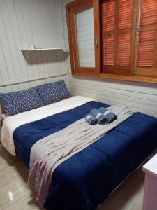 uma cama grande com lençóis azuis num quarto em Pousada Encantos Da Montanha em Lauro Müller