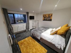 a bedroom with a bed with yellow pillows and a window at Nice cottage in the countryside in Foleshill