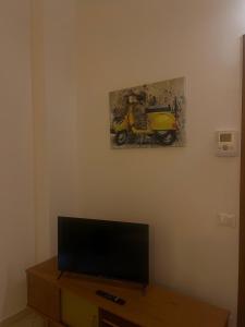 un salon avec une télévision et une peinture murale dans l'établissement Un terrazzo sul centro storico, à Reggio d'Émilie