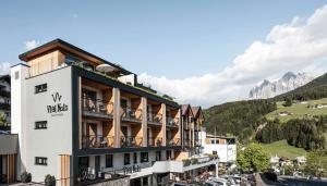 un edificio alberghiero con vista sulle montagne di Viel Nois Guest House a Funes