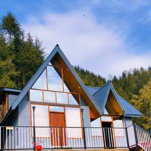 Snowind Cottages في كوفري: منزل به سقف ازرق ونوافذ