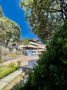 a building in the middle of a park with trees at Sea Hawk - Luxury Hill Resort 4 mins from Bhimtal Lake in Bhīm Tāl +90 photos
