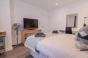 a bedroom with a bed and a flat screen tv at Exquisite Double Room in Beckenham