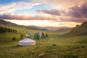 uma tenda cúpula num campo com montanhas ao fundo em Dream Adventure Mongolia em Nalayh