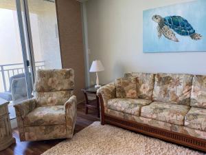 a living room with a couch and a chair at Pelican Condominium in New Smyrna Beach
