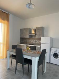 una cucina con un tavolo con sedie e una stufa di Miramare a Balestrate Altre 11 foto