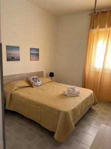 una camera da letto con un letto e un asciugamano sopra di Miramare a Balestrate