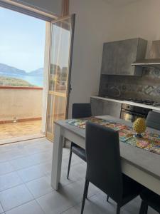 una cucina con tavolo e vista sull'oceano di Miramare a Balestrate