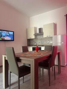 una cucina con tavolo con sedie e frigorifero di Miramare a Balestrate