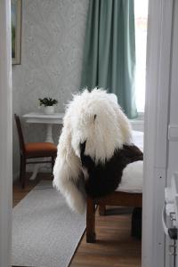 a white stuffed animal sitting on a bed at Putkisalon Kartano Hellahuoneisto in Rantasalmi