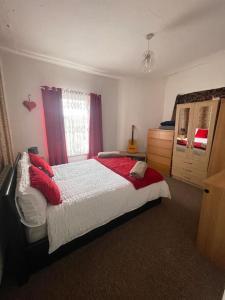 伯明罕的住宿－One bed flat，一间卧室配有一张带红色枕头的大床