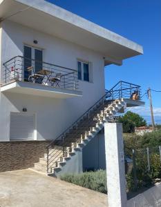 Una casa blanca con escaleras y una bicicleta. en Villa Delfini, en Chrani