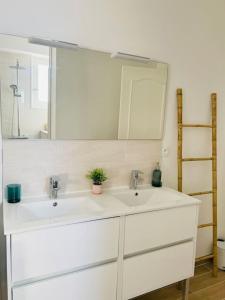 a white bathroom with two sinks and a mirror at Perpignan gare calme spacieux jolie vue netflix in Perpignan +21 photos