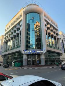 a car parked in front of a large building at GSS Avenue Hotel Ex Delmon Hotel in Dubai