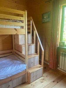 ein Etagenbett aus Holz mit einer Treppe in einem Zimmer in der Unterkunft Prince Guest House in Dilidschan