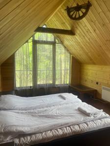 ein großes Bett in einem Zimmer mit einem großen Fenster in der Unterkunft Prince Guest House in Dilidschan