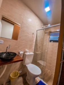 a bathroom with a toilet and a sink and a shower at Aloha Oe Itaguá in Ubatuba