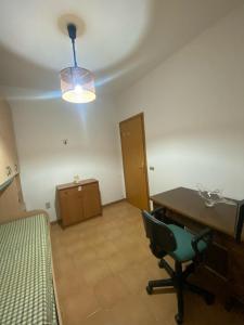 Habitación vacía con escritorio, cama y lámpara en casa vacanze Ivan 2, en Marsala