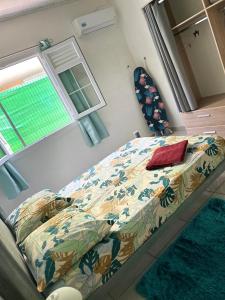 een groot bed in een slaapkamer met een sprei en een raam bij Maison tartanaise in La Trinité