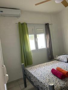 a bedroom with a bed and a window at Maison tartanaise in La Trinité