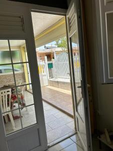 eine offene Tür zu einem Balkon mit einer Terrasse in der Unterkunft Maison tartanaise in La Trinité