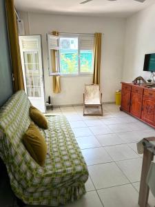 uma sala de estar com um sofá e uma cadeira em Maison tartanaise em La Trinité