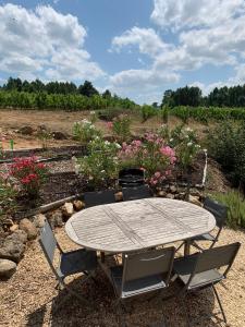 un tavolo e sedie in un giardino fiorito di Mas Héritage a Rosières