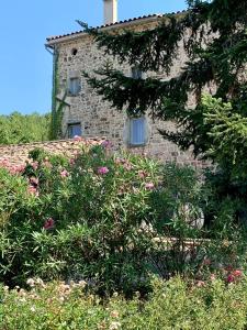 an old stone building with flowers in front of it at Mas Héritage in Rosières +5 photos