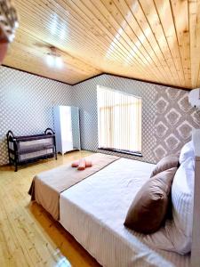 uma cama grande num quarto com tecto em madeira em Gabala luks house em Gabala