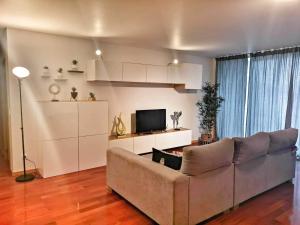 uma sala de estar com um sofá e uma televisão em Praia em Vila do Conde em Azurara