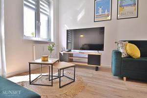 un salon avec un canapé et une table dans l'établissement Sunset Apartments - Monte Cassino 6 - przestronny apartament przy deptaku, à Świnoujście