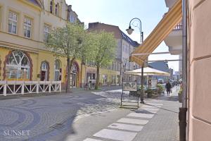 une rue dans une ville avec des bâtiments et un parapluie dans l'établissement Sunset Apartments - Monte Cassino 6 - przestronny apartament przy deptaku, à Świnoujście