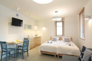 a bedroom with two beds and a table and a kitchen at Dom Wakacyjny Solano in Ustka