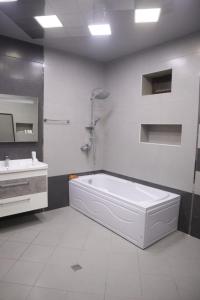 Baku Red Villa في باكو: حمام أبيض مع حوض ومغسلة