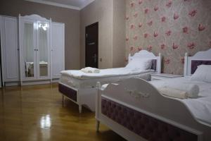a bedroom with two beds and a wall with flowers at Baku Red Villa in Baku
