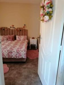 1 dormitorio con 1 cama y una corona de flores en la puerta en Appartement meublée f3 en Argel