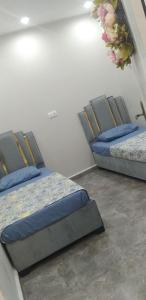 2 Betten in einem Zimmer neben einer Wand in der Unterkunft Appartement meublée f3 in Alger