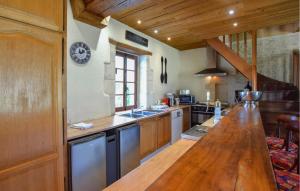 una cocina con una barra de madera larga en una habitación en Gorgeous Home In Vienne-en-bessin With Private Swimming Pool, Can Be Inside Or Outside en Vienne-en-Bessin