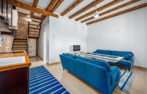 a living room with blue couches and a table at Cozy Home In Koromacno in Koromačno