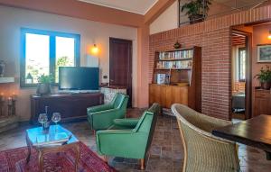 un salon avec des fauteuils verts et une télévision dans l'établissement Gorgeous Home In Graniti With Wifi, à Graniti