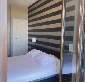 łóżko w pokoju ze ścianą w paski w obiekcie As Garzas w mieście Barizo