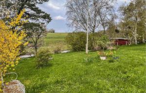 een grasveld met een rode schuur op de achtergrond bij Awesome Home In Kirke Hyllinge With Wifi in Kirke-Hyllinge