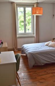 1 dormitorio con cama, ventana y mesa en Appartement 3 pièces très lumineux, en Saint-Vallier