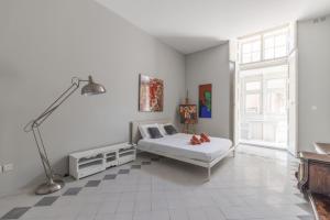 a white bedroom with a bed and a lamp at THE ARTIST'S LOFT in Valletta