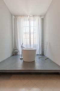 a white bath tub in a room with windows at THE ARTIST'S LOFT in Valletta